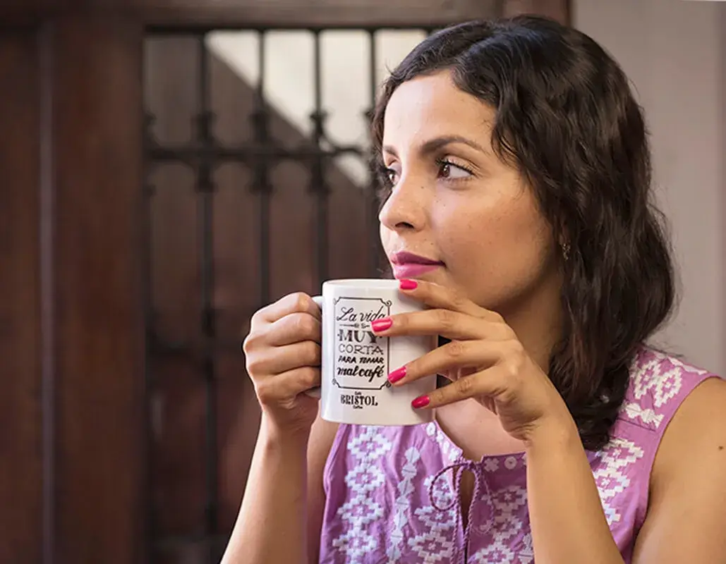 Mujer con taza de café y cita escrita